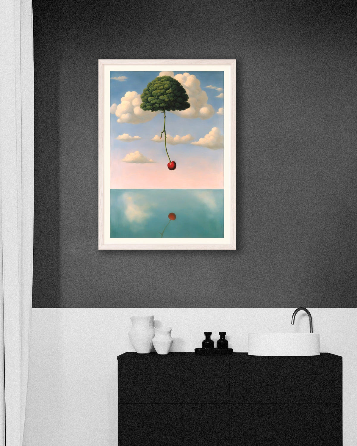 Bathroom with a dark gray wall and a framed surreal poster of a tree floating in the sky with a red cherry, above a black vanity